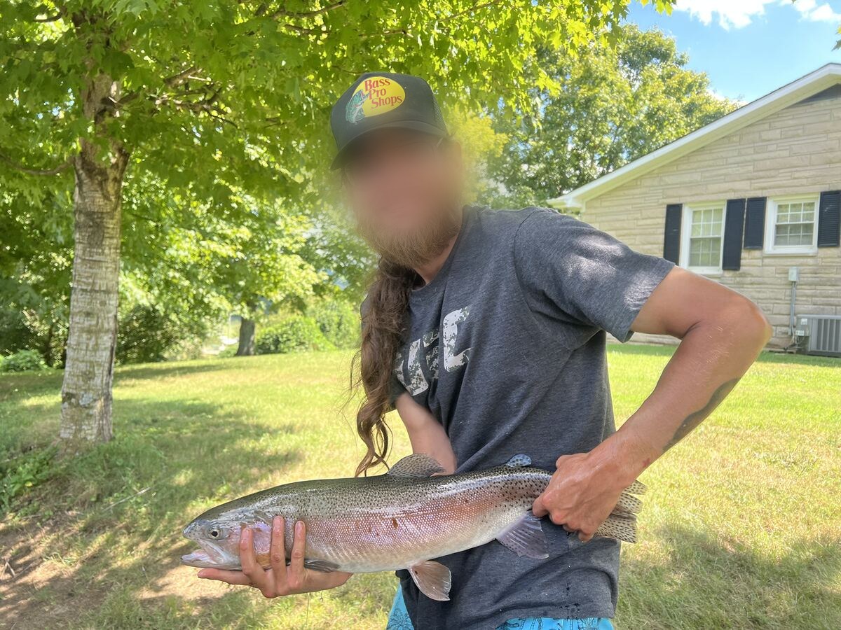 Happy angler holding a rainbow trout caught on the Obey River